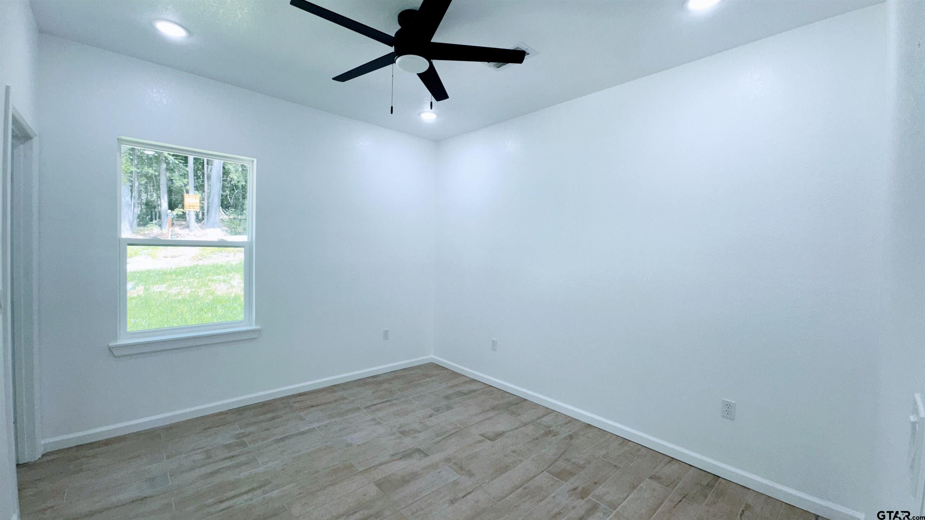 20428 High Point Drive Flint, TX 75762 - Photo 10 of 18 an empty room with a window and a fan