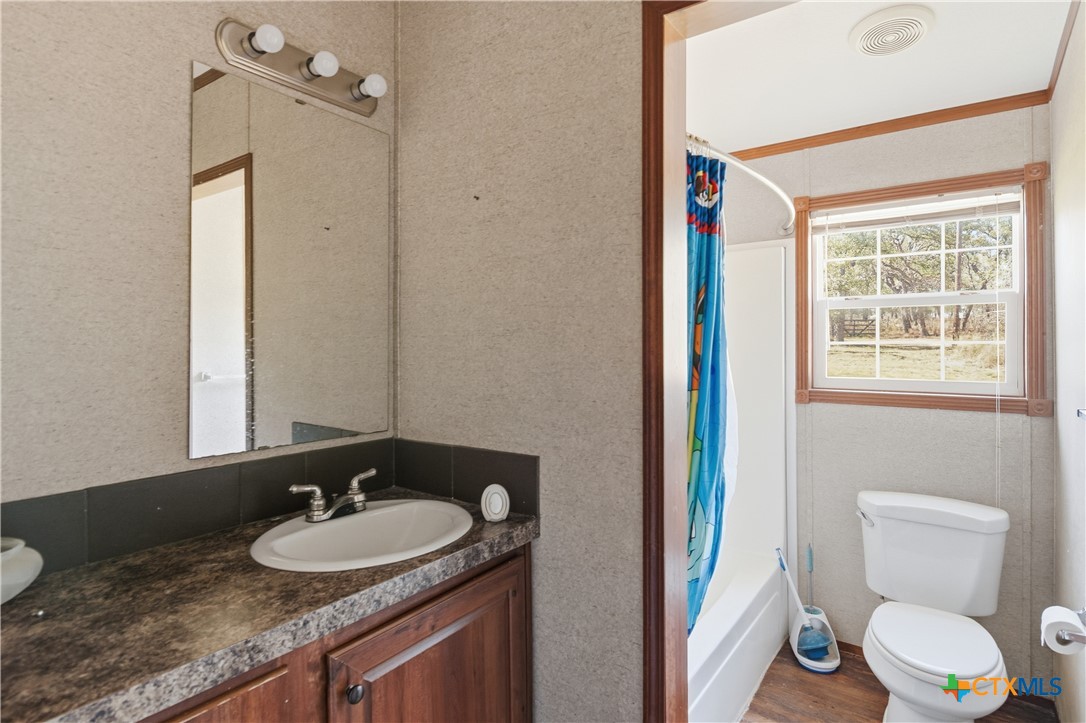 780 Oak Tree Road Seguin, TX 78155 - Photo 14 of 40 a bathroom with a granite countertop sink toilet and a mirror