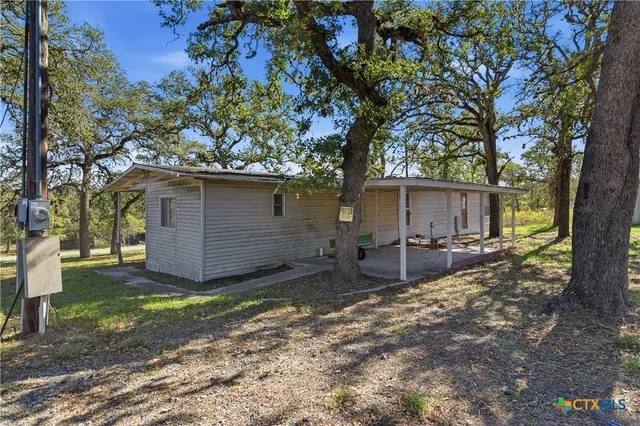 a view of a house with backyard and tree