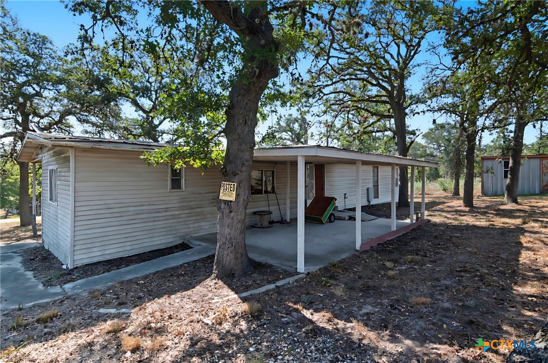 780 Oak Tree Road Seguin, TX 78155 - Photo 20 of 40 a view of a house with backyard chairs and a large tree