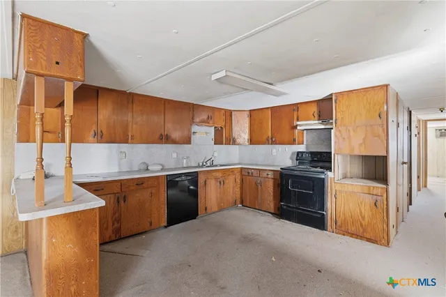 a kitchen with granite countertop a sink stove and refrigerator