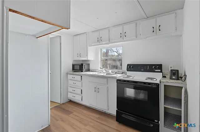 a kitchen with cabinets stainless steel appliances and a sink