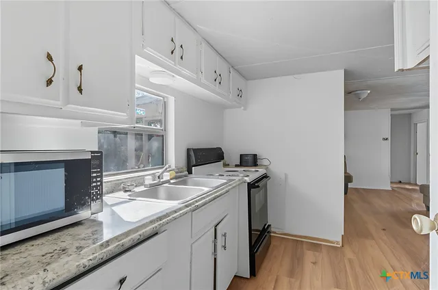 a bathroom with a granite countertop sink toilet and washing machine