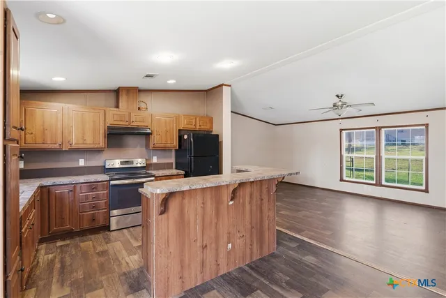 a kitchen with stainless steel appliances granite countertop a stove a sink and a refrigerator