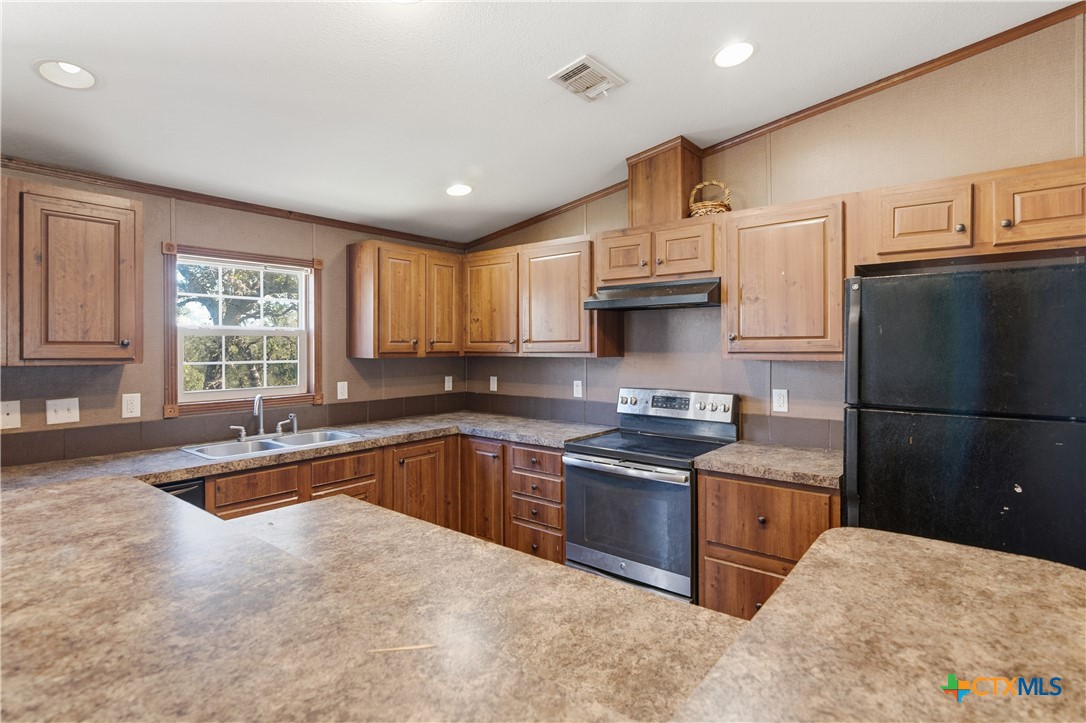 780 Oak Tree Road Seguin, TX 78155 - Photo 7 of 40 a kitchen with stainless steel appliances granite countertop a sink stove and refrigerator