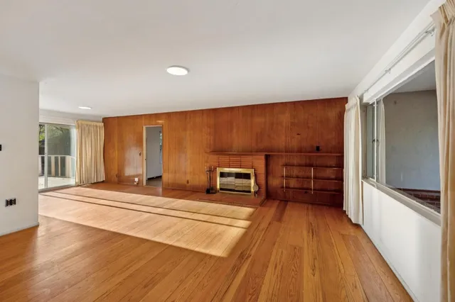 a spacious bedroom with a bed and wooden floor