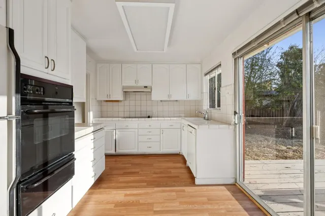 a kitchen with white cabinets and stainless steel appliances