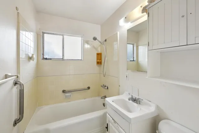 a bathroom with a sink mirror bathtub and toilet