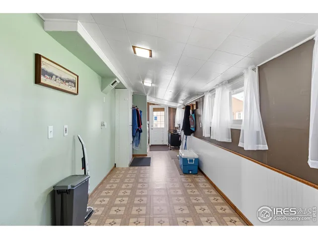 a view of a hallway with furniture and a window