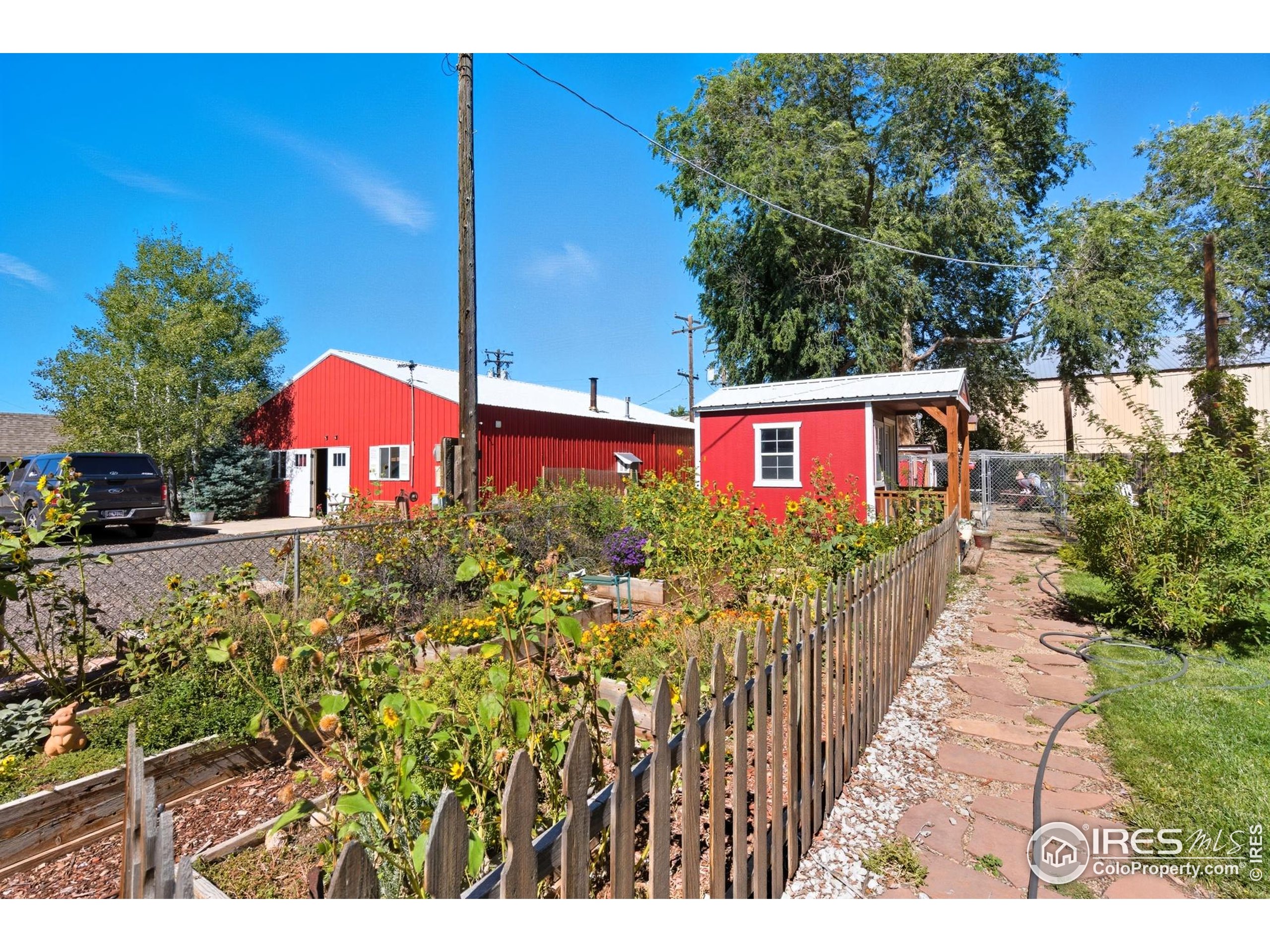 103 West Main Street Pierce, CO 80650 - Photo 28 of 47 a view of a street with flower plants and wooden fence