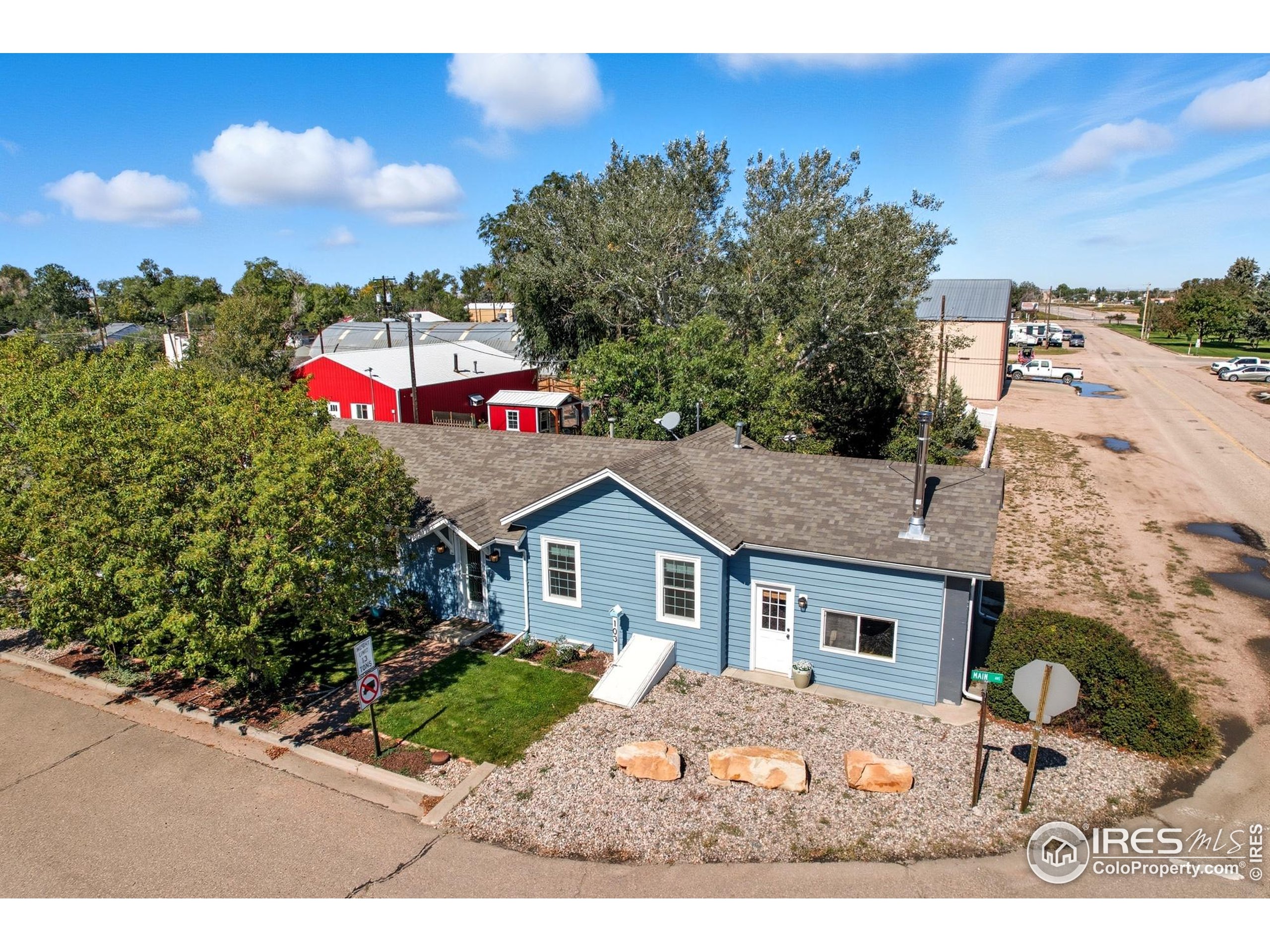 103 West Main Street Pierce, CO 80650 - Photo 43 of 47 a yellow and red house with a tree in front of it