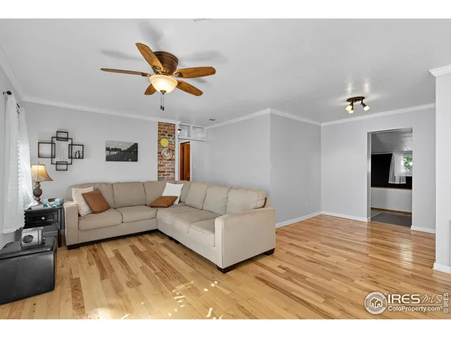 a living room with furniture and a dining table with wooden floor