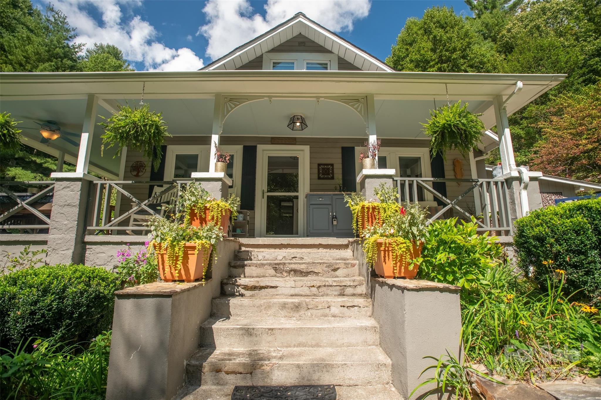 296 Sparks Road Bakersville, NC 28705 - Photo 7 of 47 front view of a house with potted plants and a bench