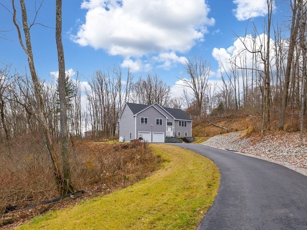 a view of a large house with a big yard and large trees