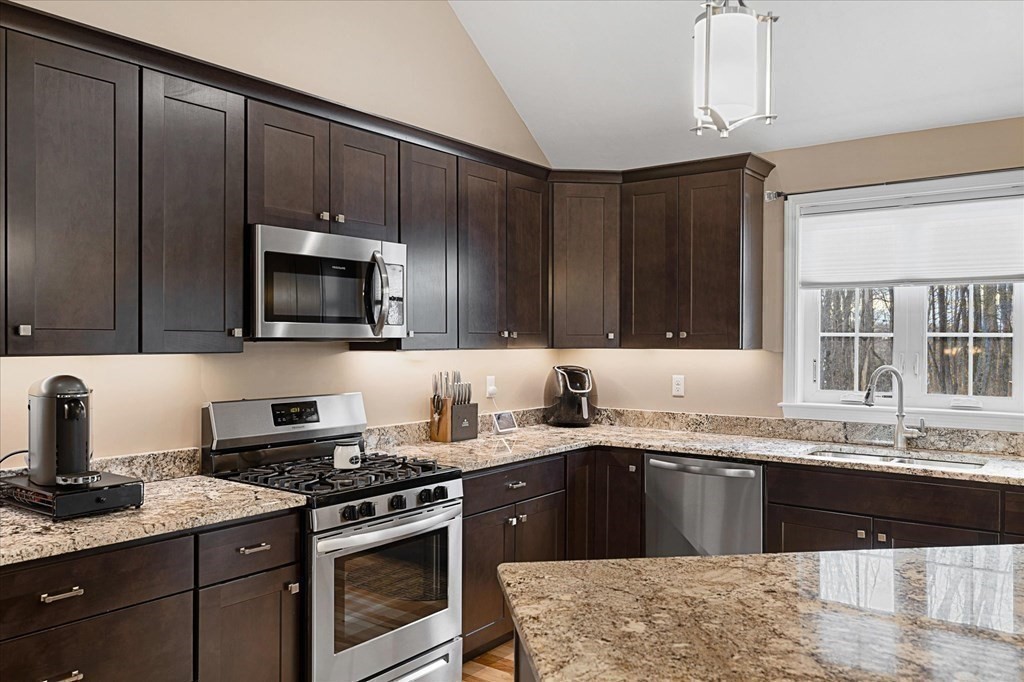 71 Dudley Hill Road Dudley, MA 01571 - Photo 12 of 32 a kitchen with granite countertop a sink a stove and cabinets