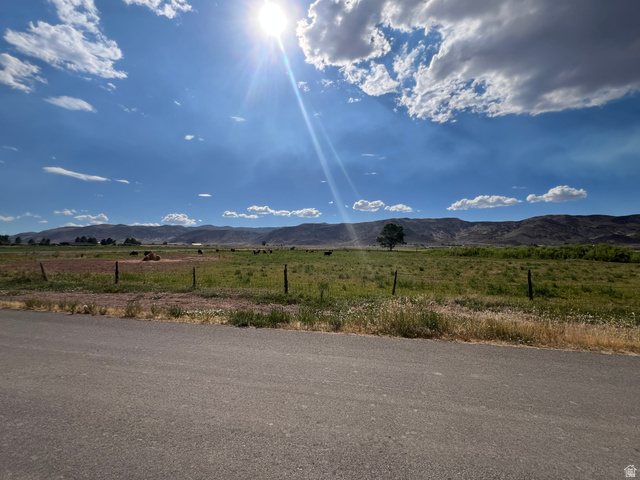950 West Old Airport Road Monroe, UT 84754 - Photo 3 of 5 Expansive rural landscape featuring a paved road, wire fencing, and vast open fields with distant mountains