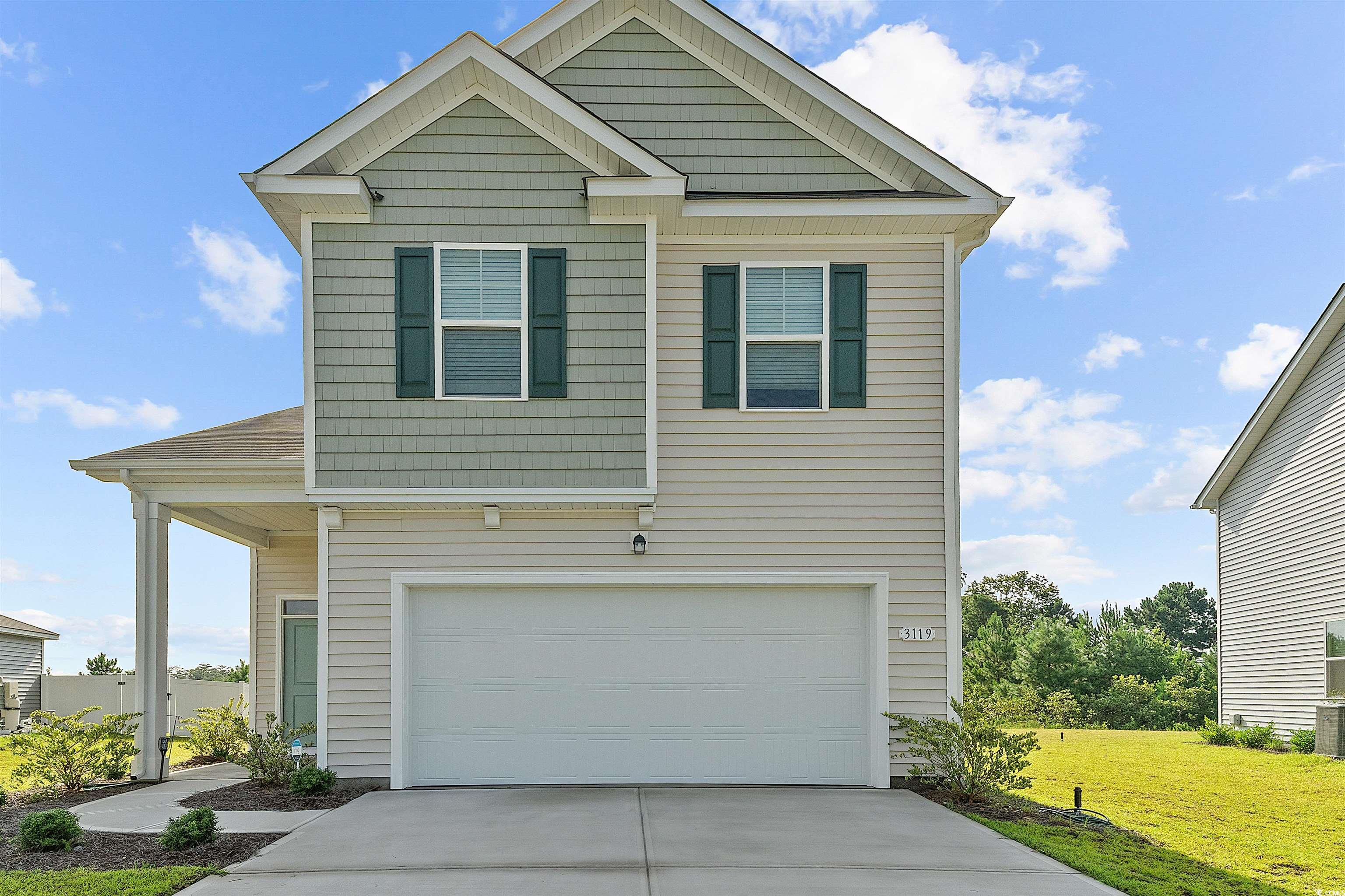 Craftsman inspired home featuring a front lawn, concrete driveway, and an attached garage