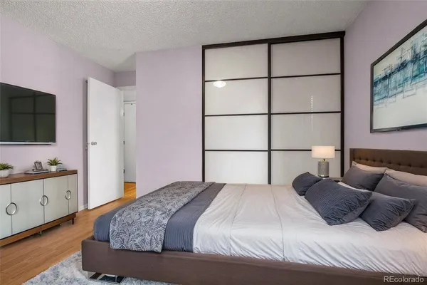 a bedroom with a large bed and a flat screen tv