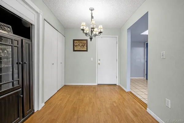 a view of a hallway with wooden floor and a kitchen