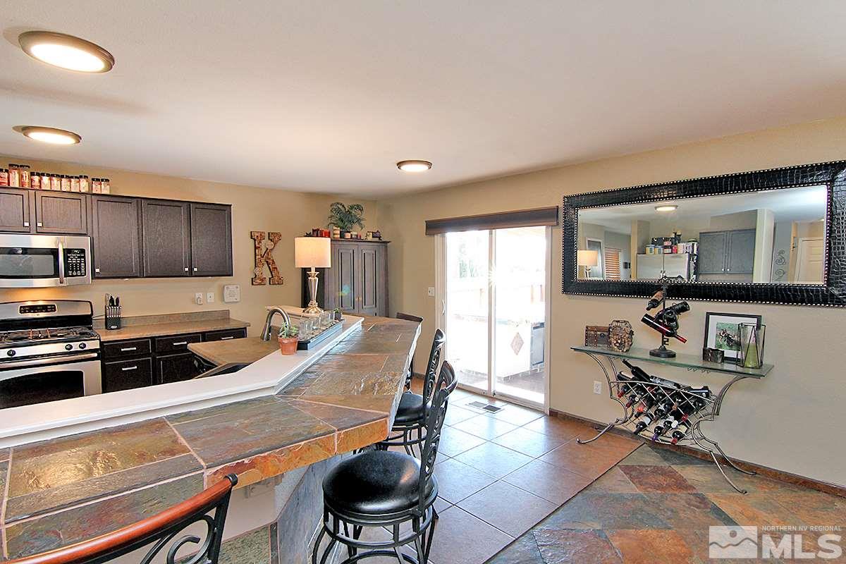 7762 Welsh Drive Reno, NV 89506 - Photo 4 of 25 a living room with stainless steel appliances furniture a dining table and kitchen view