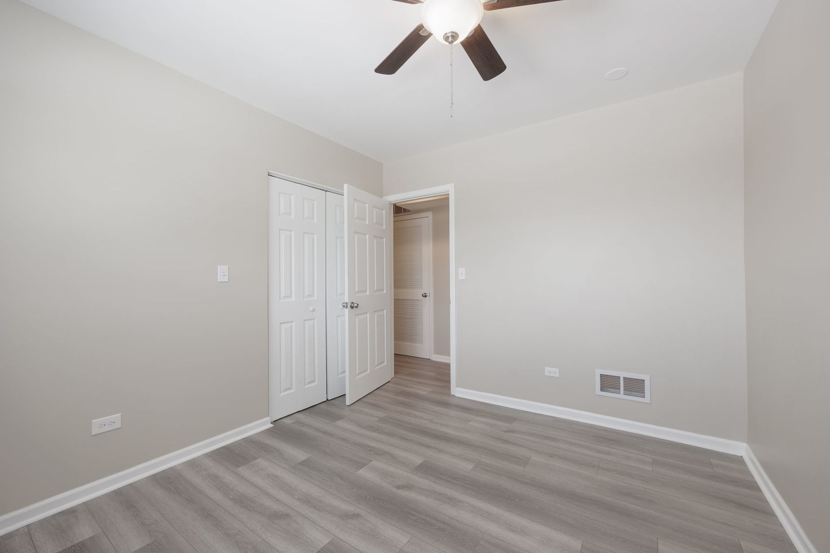 11933 South Pulaski Road, Unit 2 Alsip, IL 60803 - Photo 5 of 11 an empty room with wooden floor ceiling fan and windows