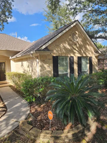 a front view of house along with road and trees