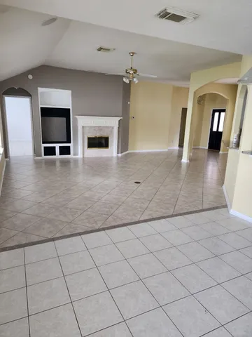 an empty room with wooden floor and fireplace