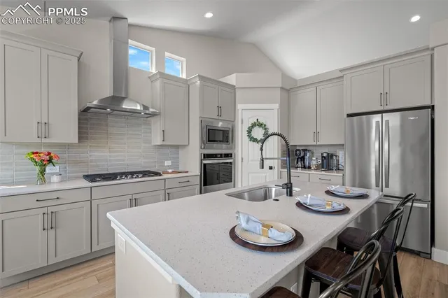 a kitchen with stainless steel appliances granite countertop a dining table and chairs