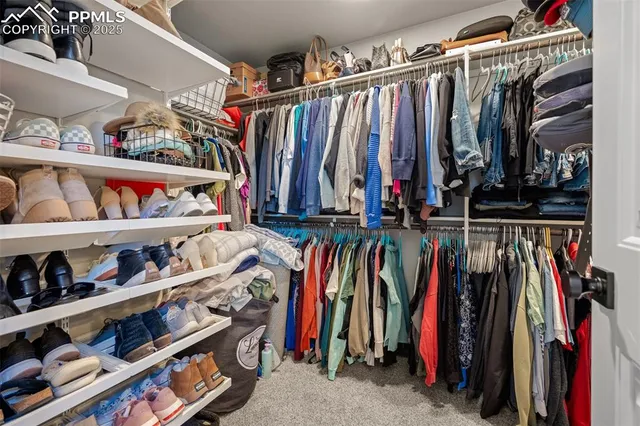 a view of walk in closet with clothes and shoes
