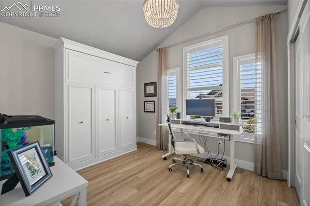 a view of a workspace with furniture and a window