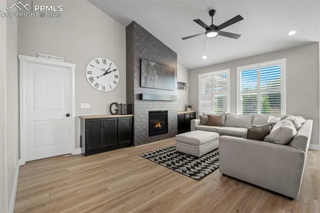 a living room with furniture a large window and a fireplace