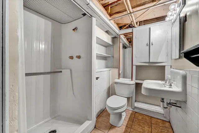 a bathroom with a toilet sink a shower and a mirror