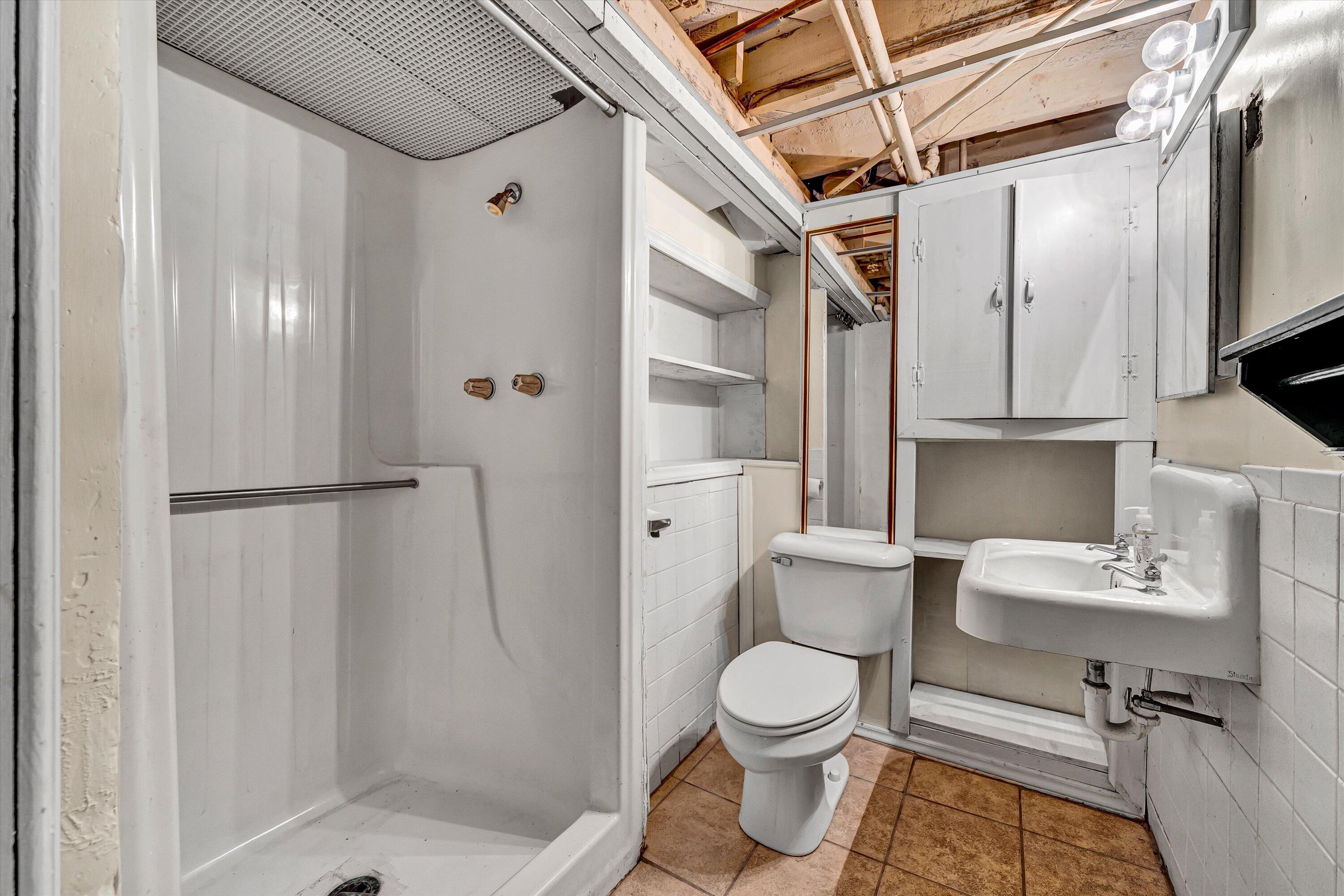 1907 Canterbury Road Southwest Roanoke, VA 24015 - Photo 27 of 36 a bathroom with a toilet sink a shower and a mirror