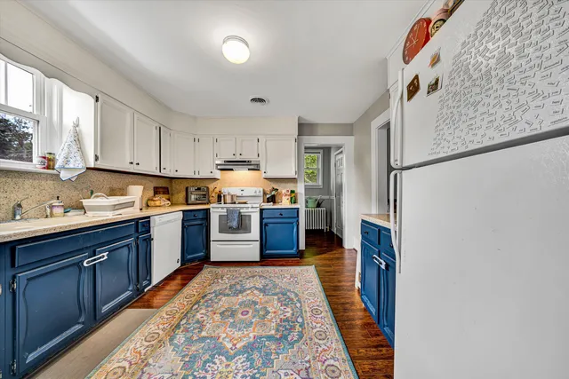 a kitchen with stainless steel appliances granite countertop a refrigerator sink and wooden cabinets