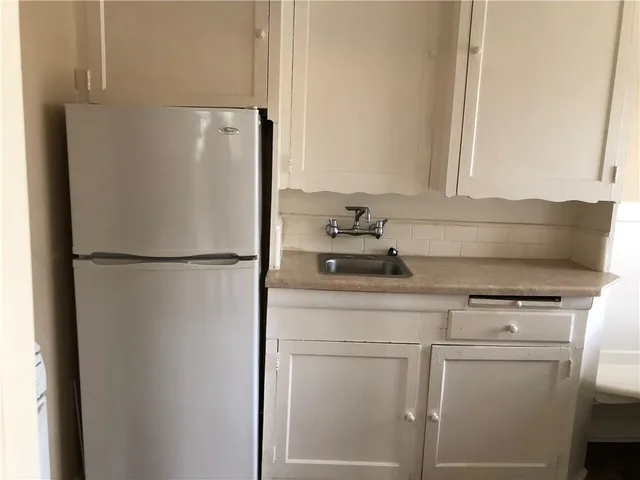 a white refrigerator freezer and a stove sitting inside of a kitchen
