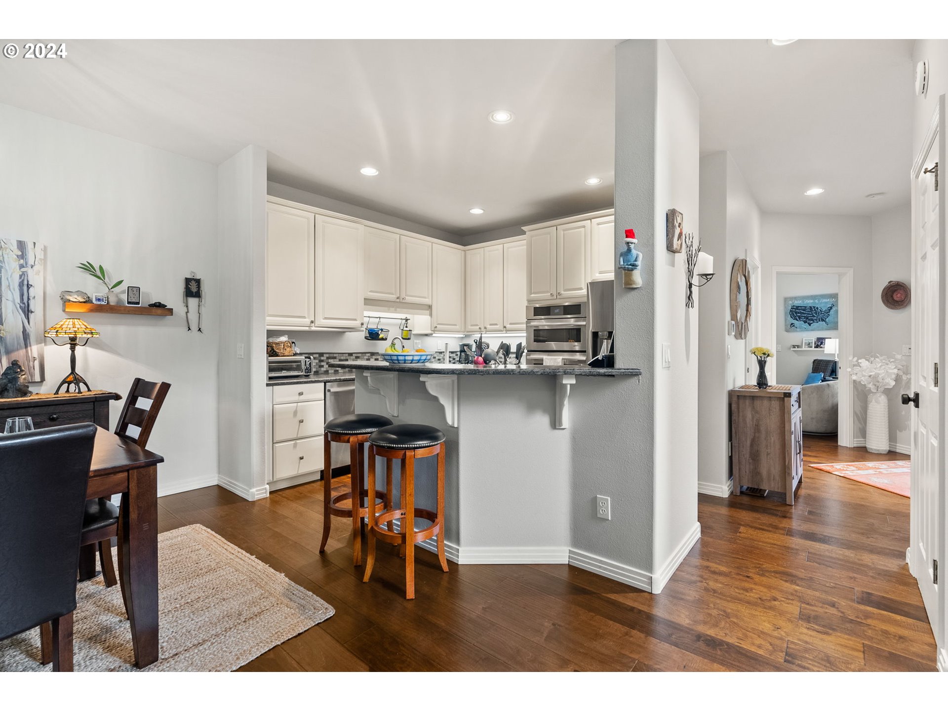 22225 Chelan Loop West Linn, OR 97068 - Photo 22 of 46 a kitchen with stainless steel appliances granite countertop a refrigerator a sink a stove a dining table and chairs