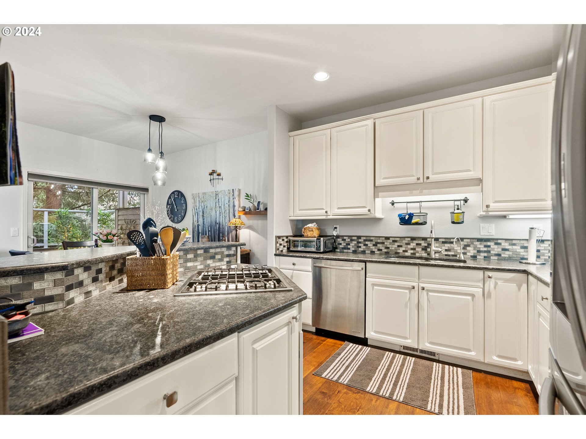 22225 Chelan Loop West Linn, OR 97068 - Photo 10 of 46 a kitchen with kitchen island granite countertop a sink stove and cabinets