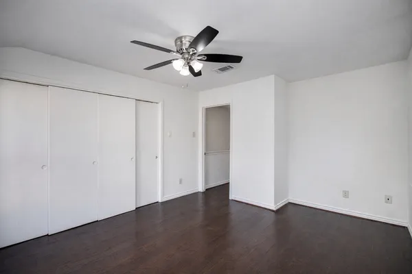 a view of a room with wooden floor and closet area