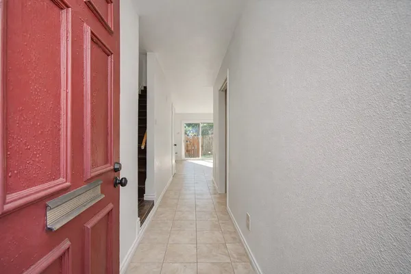 a view of a hallway with wooden floor and staircase