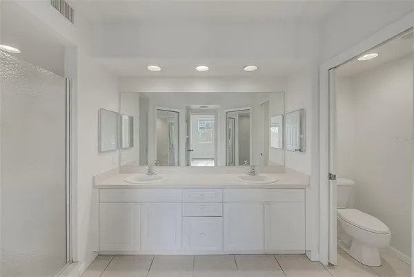 a bathroom with a shower sink and mirror