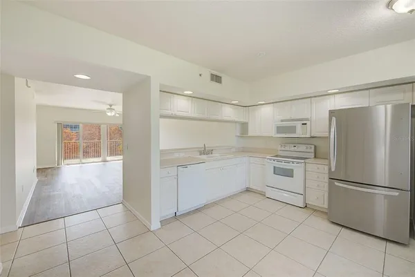 a kitchen with white cabinets and white appliances