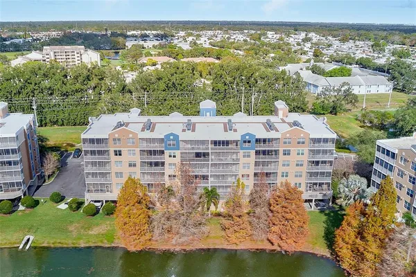 an aerial view of residential houses with outdoor space and lake view