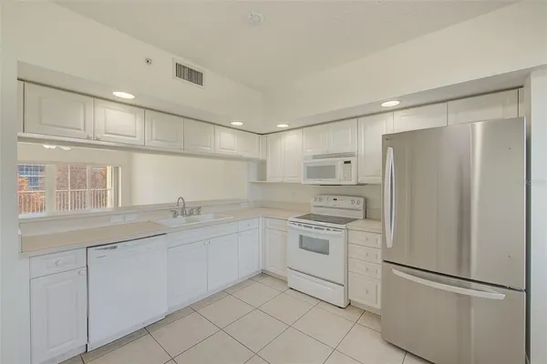 a kitchen with white cabinets and white appliances
