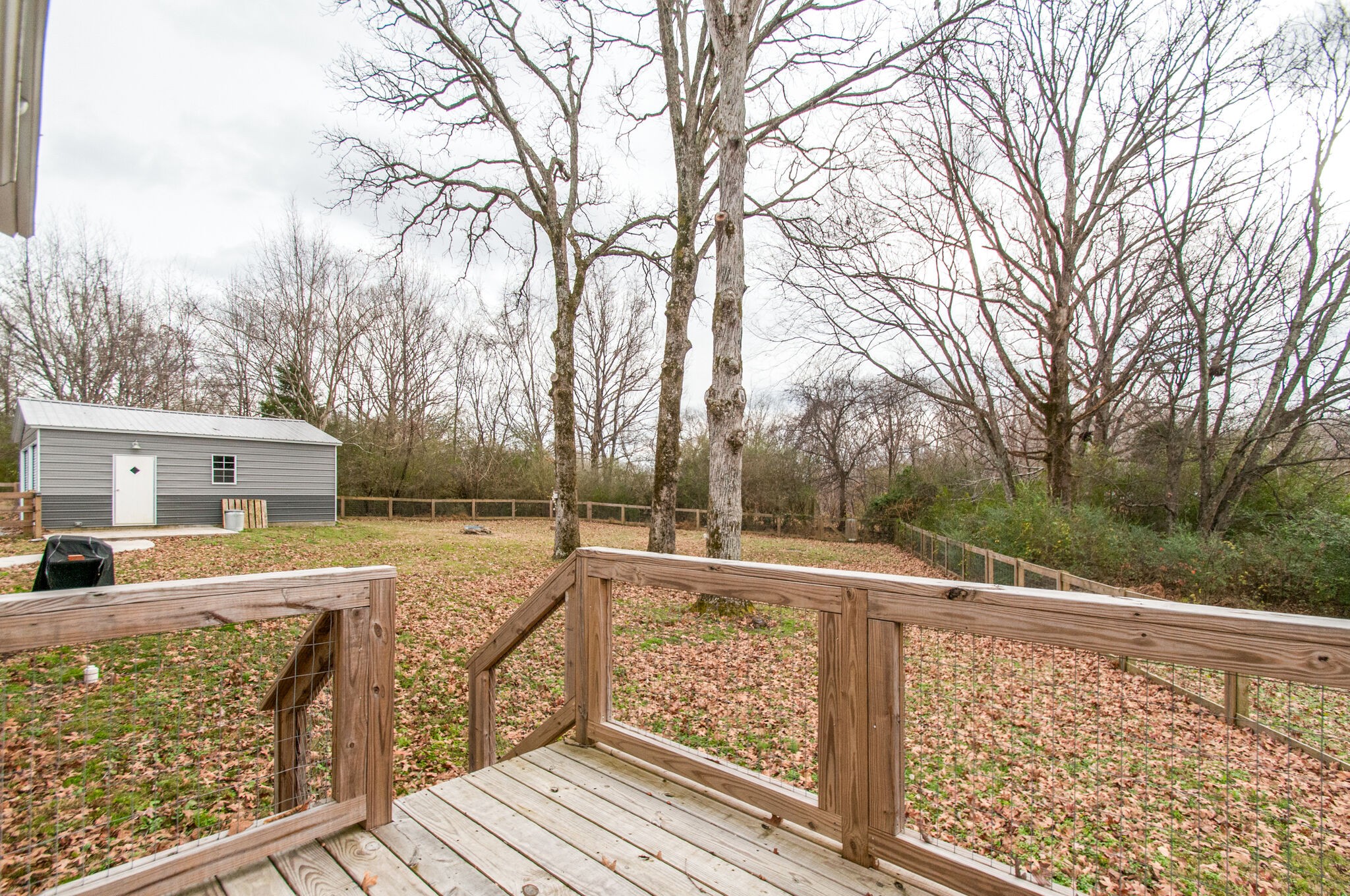 7377 Taylor Road Fairview, TN 37062 - Photo 7 of 22 a view of a balcony with wooden fence and large trees