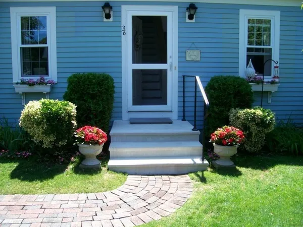 a front view of a house with a yard and fountain