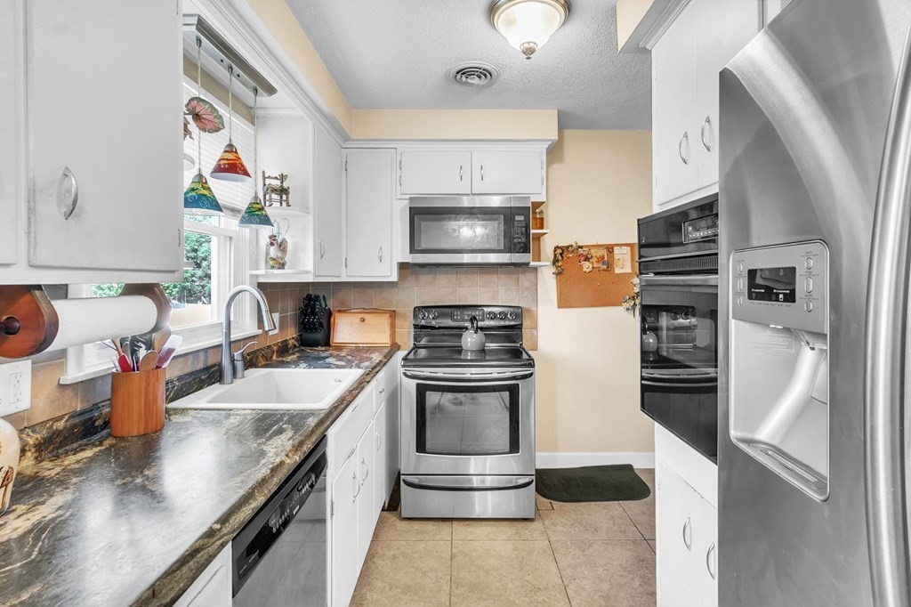 48 Greenlawn Street Springfield, MA 01119 - Photo 4 of 39 a kitchen with stainless steel appliances granite countertop a stove and a refrigerator