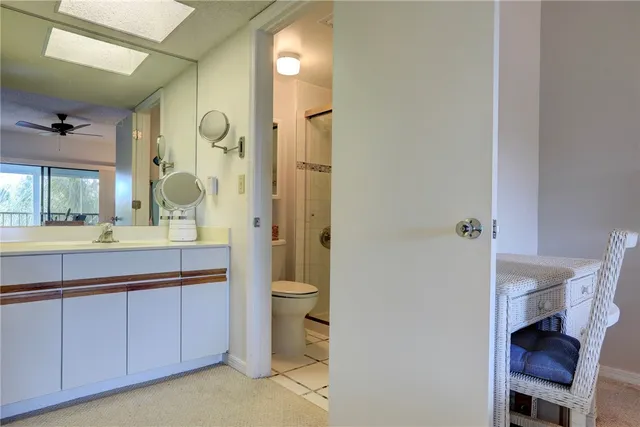 a bathroom with a granite countertop sink a toilet and a mirror