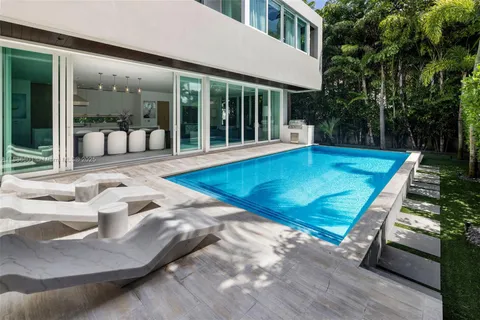a view of a house with pool and sitting area
