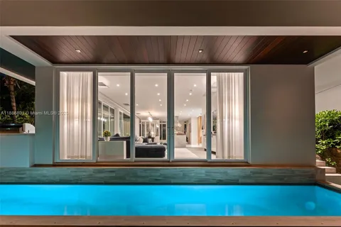 a view of a living room and floor to ceiling window with furniture