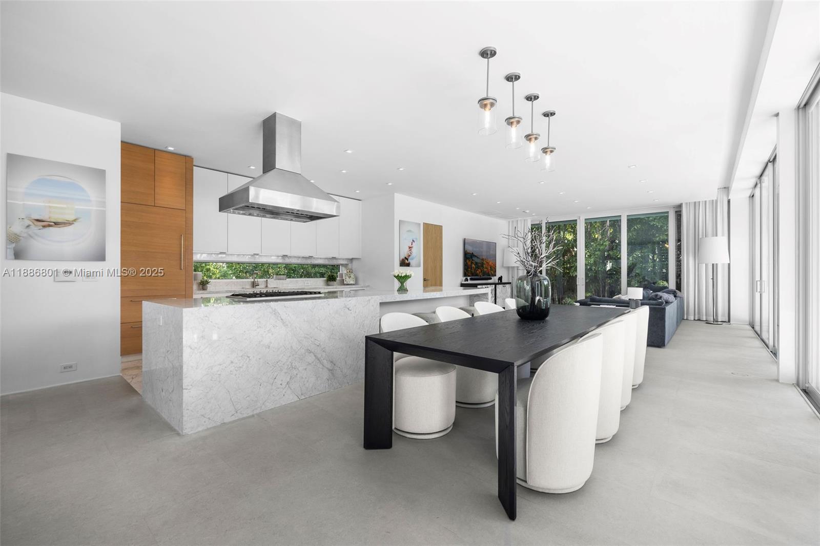 4433 North Bay Road Miami Beach, FL 33140 - Photo 32 of 71 a kitchen with stainless steel appliances kitchen island granite countertop a table and chairs